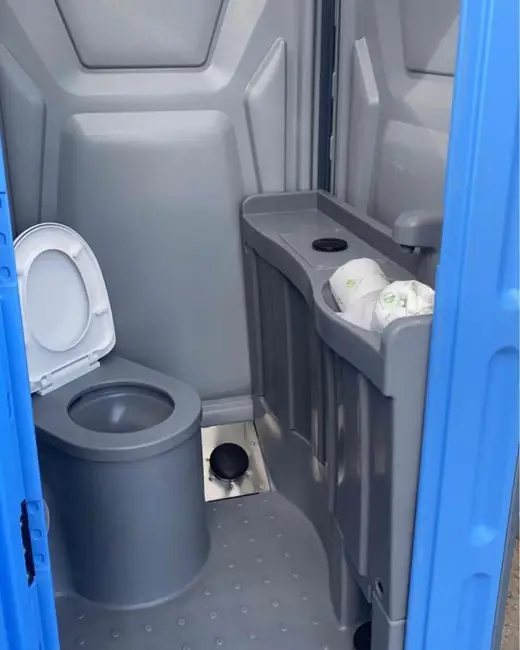 Inside a flushing porta potty with sink