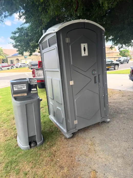 Portable toilet and hand wash station on a lawn